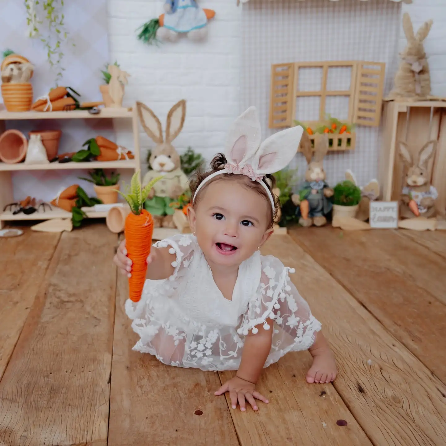 Bebê sorrindo e explorando um cenário claro, simples e delicado.